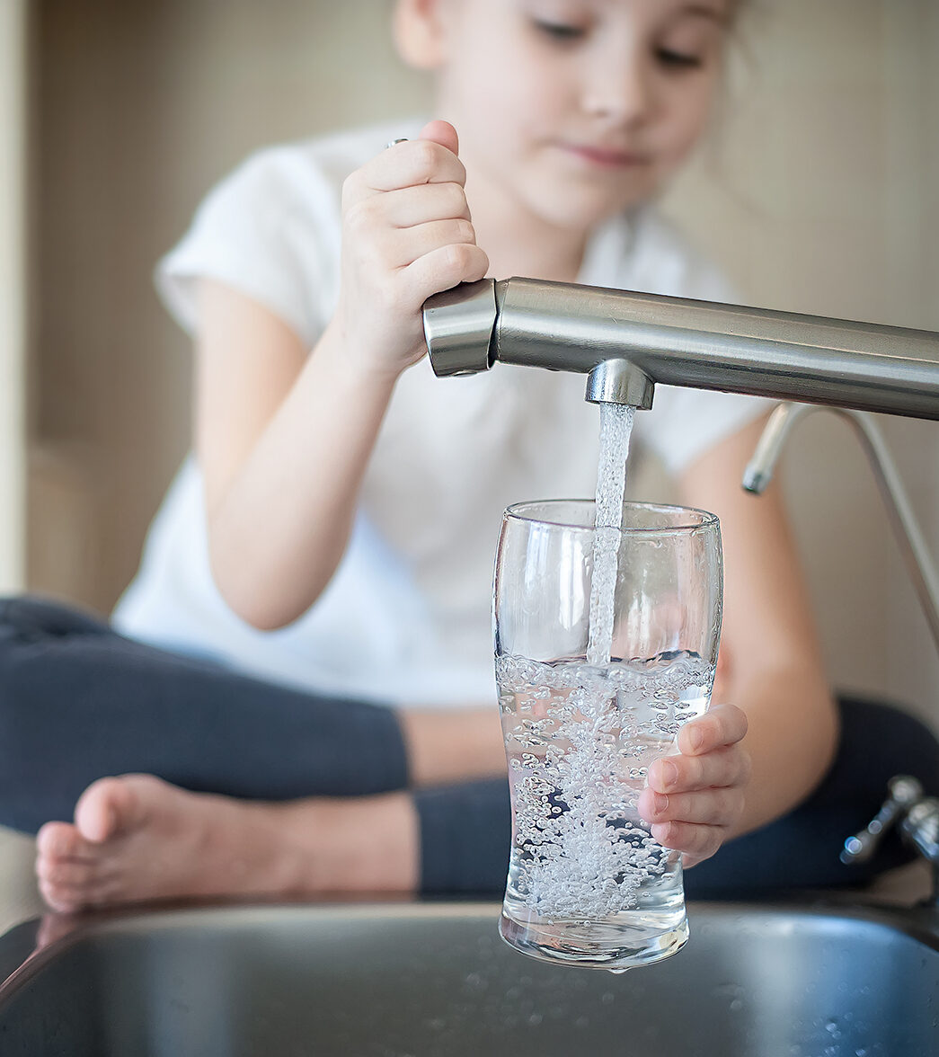 Girl filling cup with filtered tap water