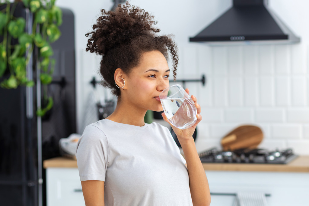 woman drinking water from glass